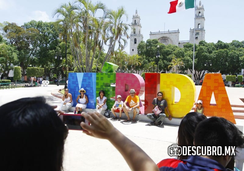 Turistas se toman una foto con las letras de Mérida en la Plaza Grande en el Centro Histórico de la ciudad blanca.