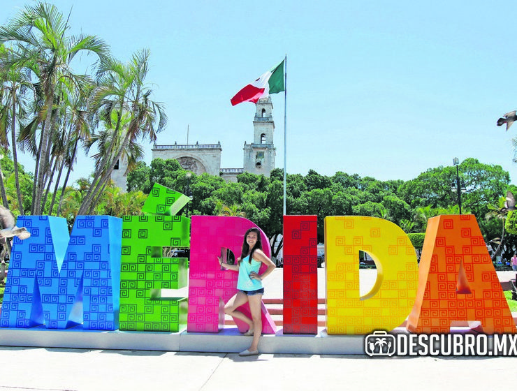 Turistas se toman una foto con las letras de Mérida en la Plaza Grande en el Centro Histórico