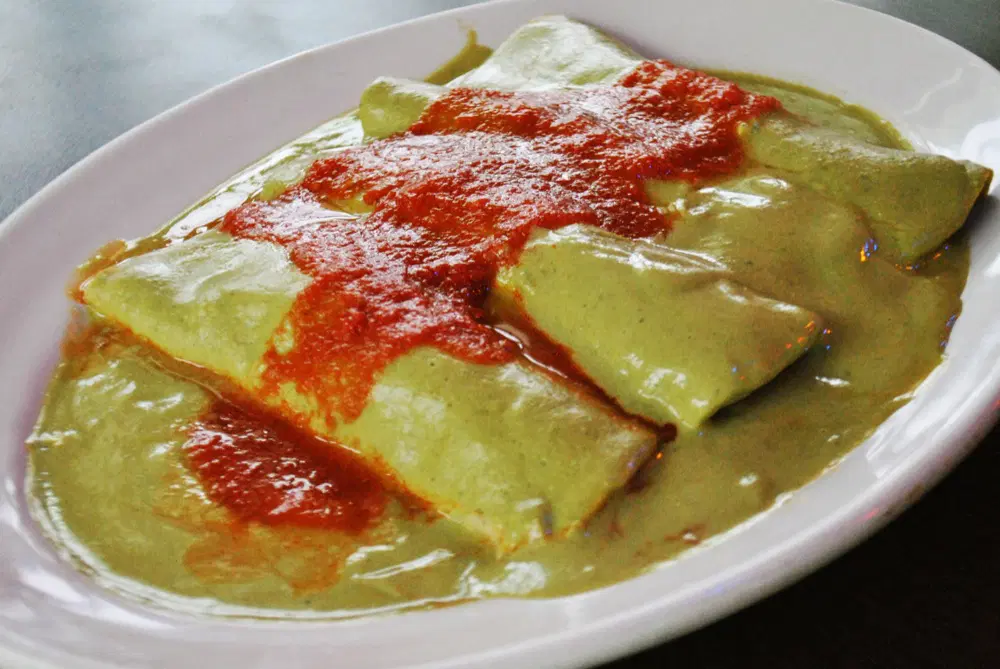 Los papadzules son unos tacos de huevo cocido, bañados con una salsa de pepita para papadzul de color verde y acompañados con una salsa de tomate